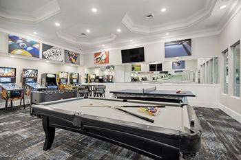 A billiard table is in the middle of a room with a white ceiling and walls.